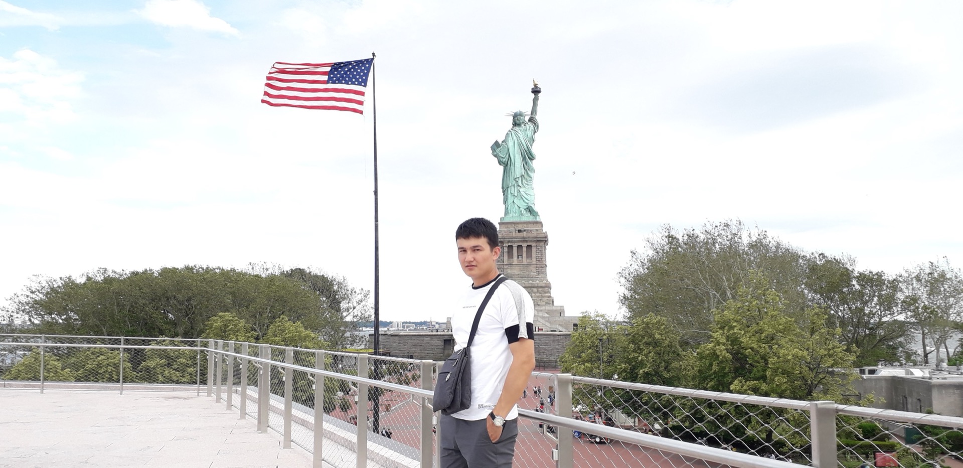 Khurshid Normurodov in front of the Statue of Liberty, New York