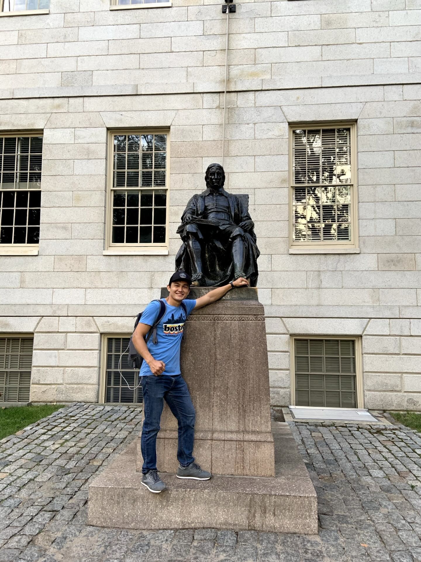 Khurshid Normurodov beside the John Harvard Statue at Harvard University