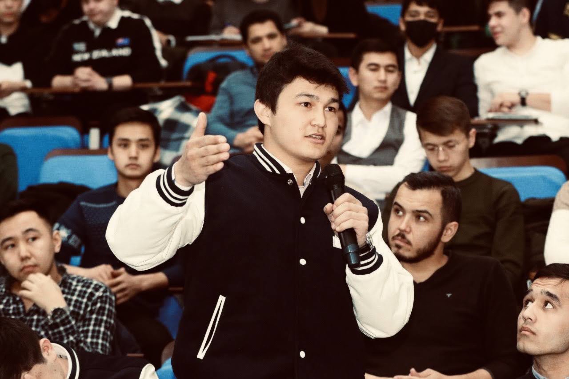 Khurshid Normurodov speaking into a microphone during an audience Q&A