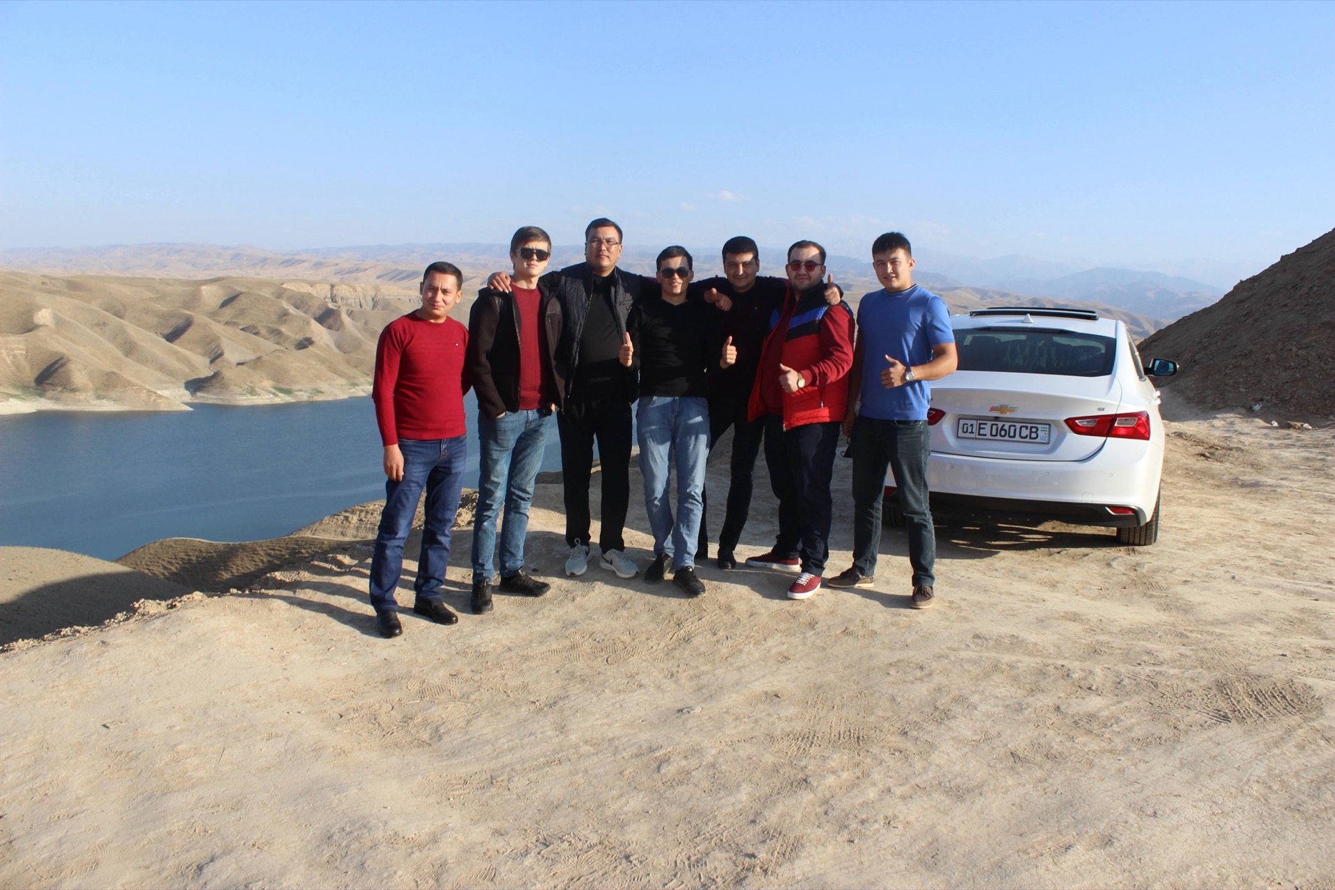 Khurshid Normurodov with colleagues overlooking a reservoir in the Uzbek mountains